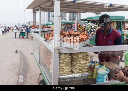Un venditore ambulante vende granchi e altri prodotti alimentari da uno stallo su Galle Face Green in Colombo, Sri Lanka Foto Stock
