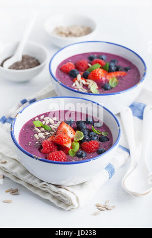 Una sana berry smoothie ciotola con Fragole Lamponi Mirtilli e semi di Chia Foto Stock