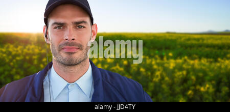 Ritratto di bello responsabile sicurezza contro la vista panoramica del bellissimo campo di senape Foto Stock