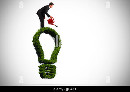 Imprenditore con irrigazione red può contro la lampadina di luce fatto di foglie Foto Stock