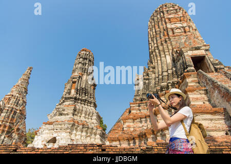 Giovane donna asiatica fotografo di scattare le foto con la professional gear foto sulla Thailandia famosa attrazione wat chaiwatthanaram tempio. Foto di sesso femminile Foto Stock