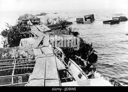 L'immagine della propaganda nazista mostra un aereo militare britannico distrutto e gli edifici sulla riva del fiume della città belga di De Panne vicino alla città francese di Dunkirk dopo l'evacuazione britannica e l'occupazione tedesca. Pubblicato nel giugno 1940. Un reporter di stato nazista ha scritto sul retro della foto su 08.06.1940, 'Un ponte fatto di camion - nel caos di Dunkerque. A la Panne vicino Dunkerque gli inglesi guidarono i loro furgoni nel mare per costruire un ponte artificiale. Durante i loro disperati tentativi, sono stati sorpresi dai nostri piloti.' Fotoarchiv für Zeitgeschichte - SENZA FILI - | usag Foto Stock