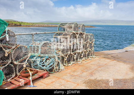 Aragosta bicchieri impilati su una banchina, Orkney REGNO UNITO Foto Stock