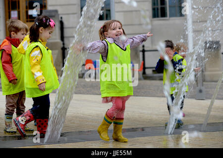 Una bambina gioca in una fontana di acqua a Barnsley PALS Giardino, South Yorkshire, Regno Unito. Foto Stock