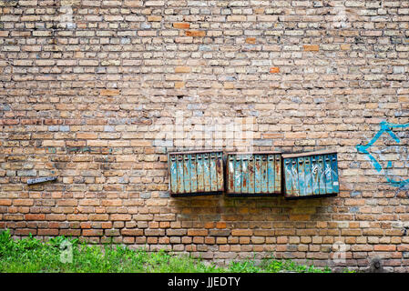 Rusty cassette postali sul mattone parete grunge Foto Stock