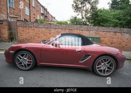 Rosso Porsche con tetto nero boxster tetto morbido colore ciliegio tetto nero convertibile veloce sportivo in pelle metallizzata manuale classico motore medio veloce Foto Stock