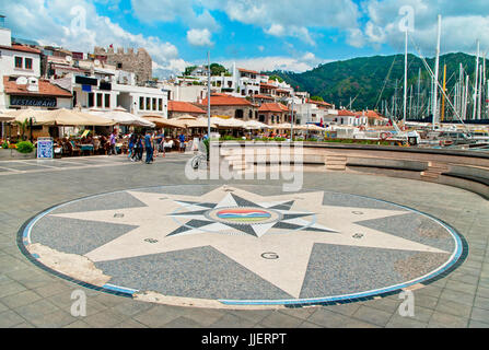 Piccola piazza con bussola a mosaico con la gente che camminava lungo il bar e il ristorante street e marina nella parte vecchia di Marmaris, Turchia Foto Stock