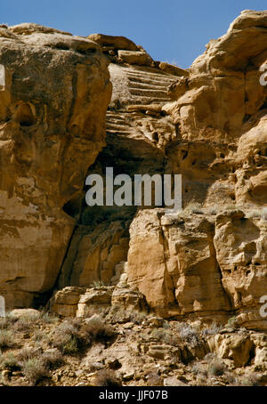 Un Anasazi rock-cut scala sulla scogliera a sud del Chaco Canyon, Nuovo Messico, solo e di Casa Riconada grande kiva & case: scalinata che si collega a una strada. Foto Stock