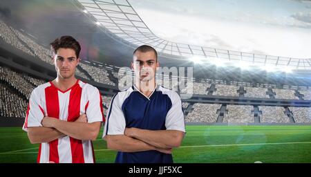 Composito Digitale dei giocatori di calcio in piedi lo stadio con le braccia incrociate contro sky Foto Stock