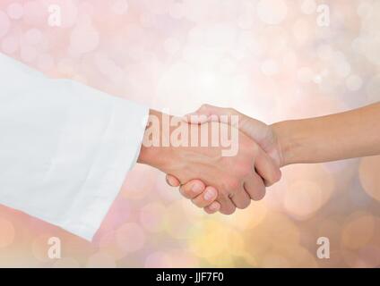 Composito Digitale delle mani scuotimento con luce sfavillante sfondo bokeh di fondo Foto Stock