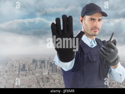 Digital composito della guardia di sicurezza con walkie talkie e mano contro skyline e nuvole Foto Stock