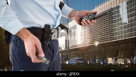 Composito Digitale della sezione centrale della guardia di sicurezza tenendo premuto i tasti e walkie talkie permanente, mentre in città Foto Stock