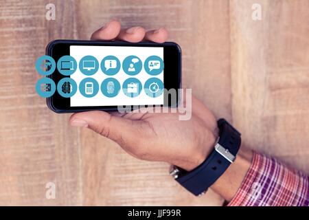Composito Digitale della mano che mostra il telefono cellulare con le icone Foto Stock