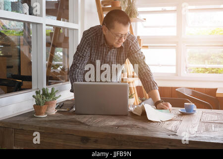 Asian grafico o interior designer scegliendo un colore da colore swatch sampler o catalogo guida della tavolozza Foto Stock