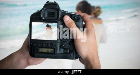 Immagine composita di immagine ritagliata di mani tenendo la fotocamera Foto Stock