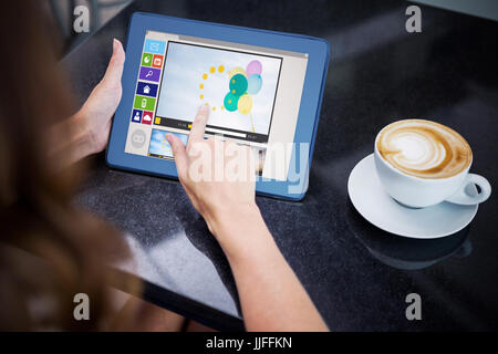 Immagine composita di vari video e icone del computer contro la donna con caffè e utilizzando il suo tablet Foto Stock