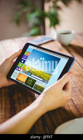 Immagine composita di vari video e icone del computer contro la donna utilizzando il suo tablet pc Foto Stock