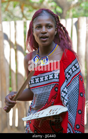 Pretty girl tribal cantando mantenga il villaggio culturale dello Swaziland Africa meridionale Foto Stock