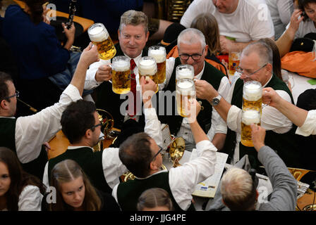 I musicisti in tradizionale costume bavarese bere birre in un festival tenda al Oktoberfest a Monaco di Baviera, Germania, il 18 settembre 2016. Dietro una ruota panoramica può essere visto. Milioni di visitatori provenienti da tutto il mondo sono nuovamente attesi per il 183rd Oktoberfest, che durerà fino al 03 ottobre 2016. Foto: ANDREAS GEBERT/dpa | Utilizzo di tutto il mondo Foto Stock