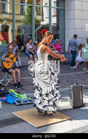 Il chitarrista e la ballerina di flamenco con il tradizionale abito bianco a ballare come street performance durante le feste estive Foto Stock