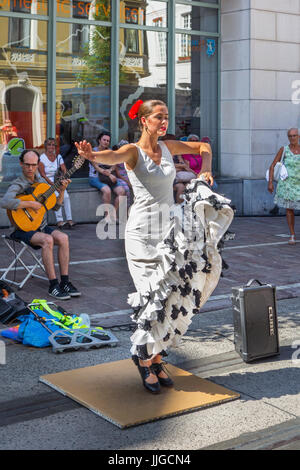 Il chitarrista e la ballerina di flamenco con il tradizionale abito bianco a ballare come street performance durante le feste estive Foto Stock