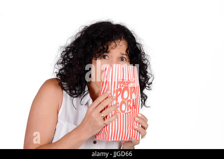 Ritratto di donna bella mangiare popcorn e guardare film. Isolato sullo sfondo bianco. Foto Stock