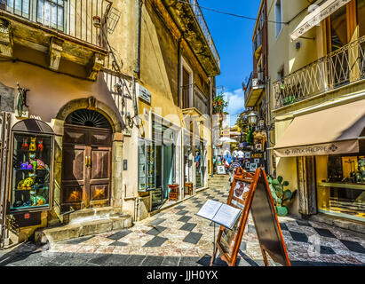 Lo shopping e le visite turistiche sull'isola Mediterranea di Sicilia, Italia nel centro storico di Taormina. Foto Stock