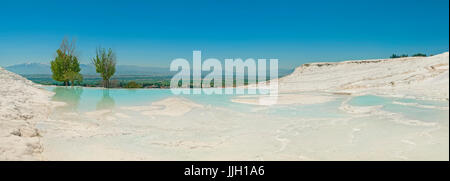 Vista panoramica di Pamukkale città dall'UNESCO Patrimonio dell'umanità di travertino bianco di terrazze con blu turchese piscine e alberi sulla soleggiata giornata estiva, Turke Foto Stock