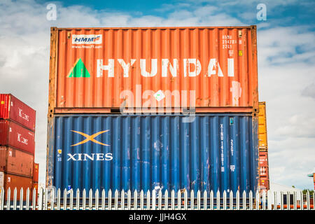 Contenitori colorati Hyundai e Xines impilati alla Tilbury Railport sul fiume Tamigi, Essex, Inghilterra, Regno Unito Foto Stock