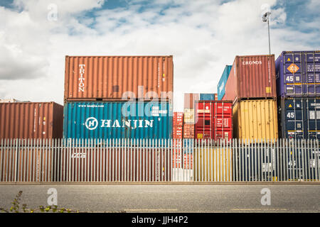 Contenitori colorati impilati a Tilbury Railport sul fiume Tamigi, Essex, Regno Unito Foto Stock