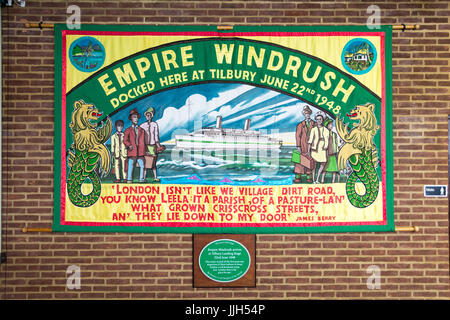 Una bandiera commemorativa dell'Impero Windrush e una targa presso il terminal delle navi da crociera di Londra, Tilbury Docks, Tilbury, Essex, Inghilterra, REGNO UNITO Foto Stock