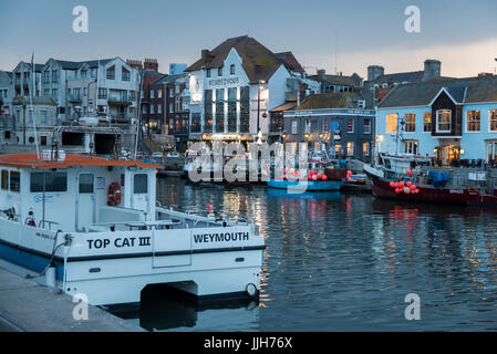 Weymouth vecchio porto al tramonto nella notte sul fiume Wey barche e sul lato del porto case colorate e pub, Weymouth Dorset,,l'Inghilterra,uk,GB Foto Stock