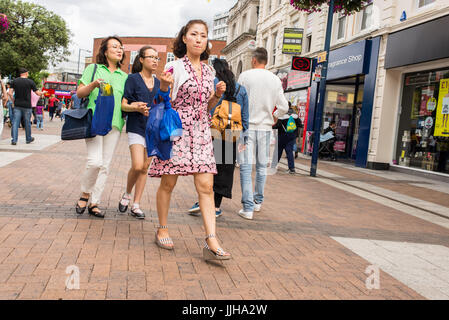 Le donne cinesi a passeggiare e a fare shopping in Clarence Street , la principale strada pedonale dello shopping a Kingston Upon Thames, London , REGNO UNITO Foto Stock