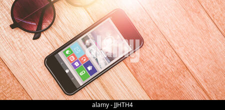 Generati digitalmente immagine dell video player con varie icone contro vista di bicchieri e uno smartphone Foto Stock