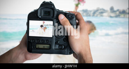 Immagine composita di immagine ritagliata di mani tenendo la fotocamera Foto Stock