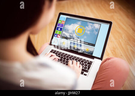 Immagine composita di vari video e icone del computer contro la donna asiatica utilizzando laptop con spazio di copia Foto Stock