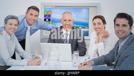 Il team di Business guardando la telecamera contro generati digitalmente immagine di vari video e icone visualizzate Foto Stock