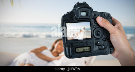 Immagine composita della mano tagliata del fotografo tenere la fotocamera Foto Stock