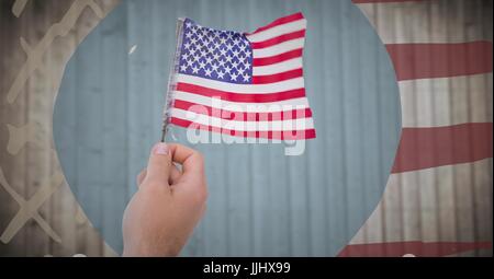 Mano azienda bandiera americana contro sfocata pannello in legno con disegnati a mano bandiera americana Foto Stock