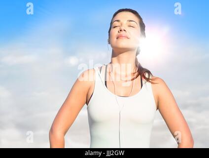 Donna prendendo il sole contro il cielo sereno con flare Foto Stock
