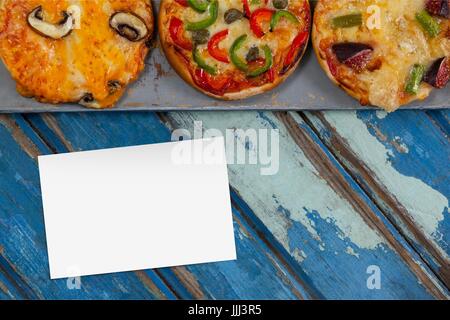 Business card blu sulla scrivania in legno con cibo e spazio copia su una scheda Foto Stock