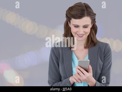 Pretty Woman texting davanti a luci colorate Foto Stock