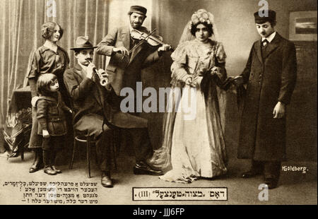 Il Mitsva / mitzva danza. Posti scena di nozze con la sposa e lo sposo e lettori di musica klezmer. parole di una canzone di nozze in Yiddish sulle carte.cartolina da Varsavia. Fotografo H.Goldberg. Foto Stock