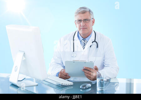 Composite 3d immagine del ritratto di fiducia medico maschile seduto alla scrivania del computer Foto Stock