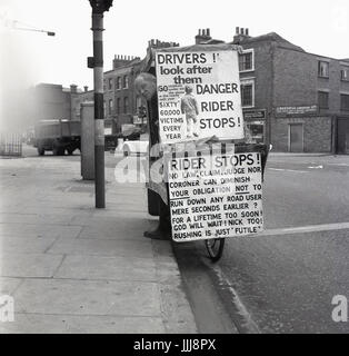 1971, Greenwich High Road, Londra, immagine mostra l'eccentrico inglese e fervente candidato poltical Lt. Com William (Bill) Boaks sulla sua "campagna bus', una bicicletta coperto con cartelli e indicazioni circa la sicurezza stradale, una causa centrale per le sue credenze.. Foto Stock