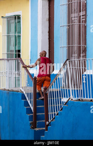 Un uomo cammina su per le scale lungo la strada - Trinidad, Cuba Foto Stock