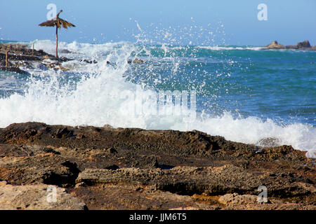 Spruzzate sulle rocce in riva al mare Foto Stock