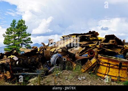 Rottami colorati in metallo junk yard contro un paesaggio naturale Foto Stock