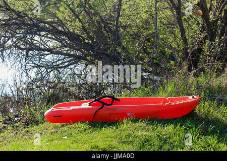 Un bambino piccolo kayak tirata fino in riva al lago bordo. Foto Stock