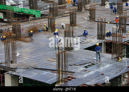 Operai della costruzione su di un alto edificio a Bangkok, in Thailandia Foto Stock